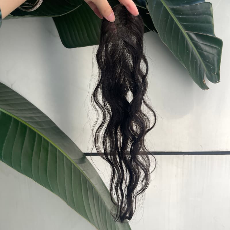 Black human hair lace topper held in hand