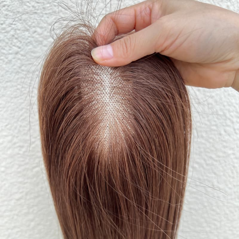 Close-up of hand-tied natural part on brown topper