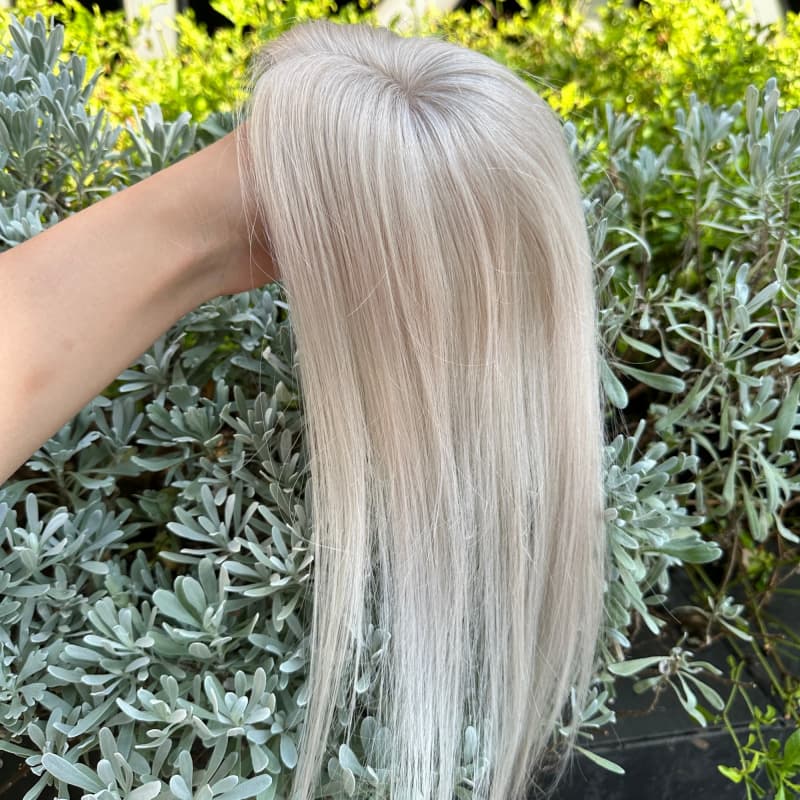 Underside of platinum blonde injected mono hair topper showing clip attachments