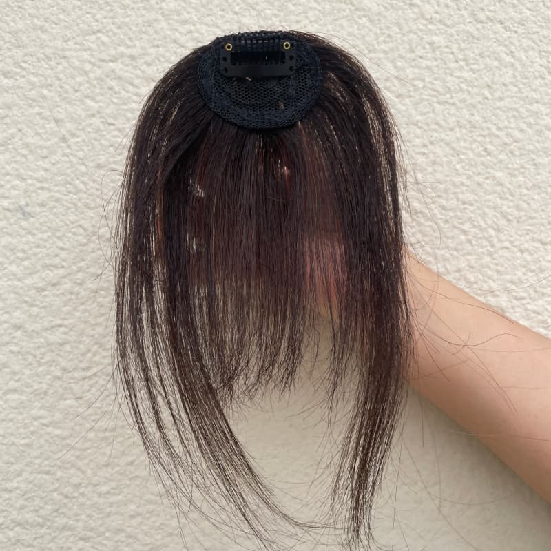 Natural black fringe hairpiece compact mesh base and single clip detail